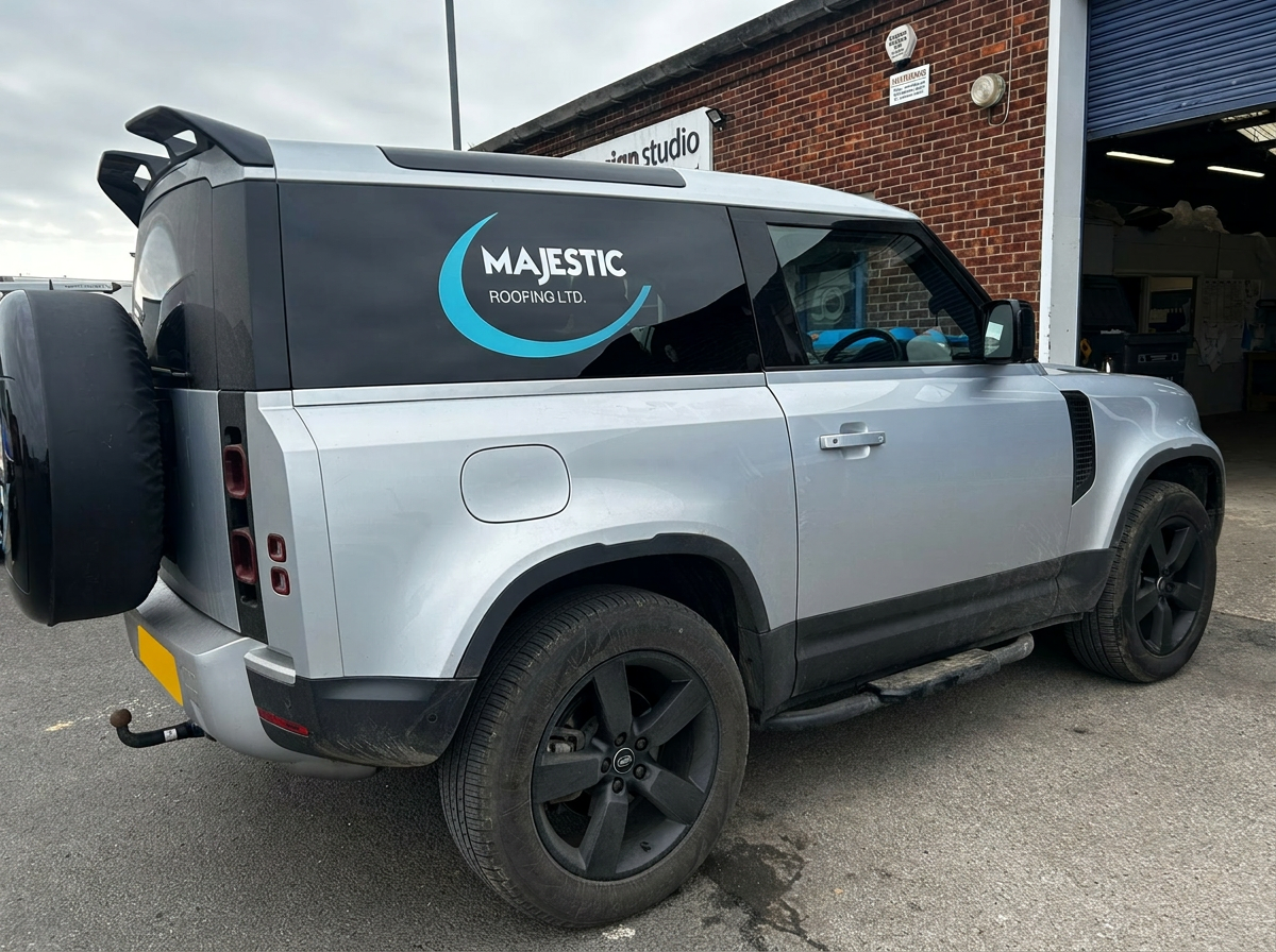 Majestic Roofing branded Land Rover Defender side view